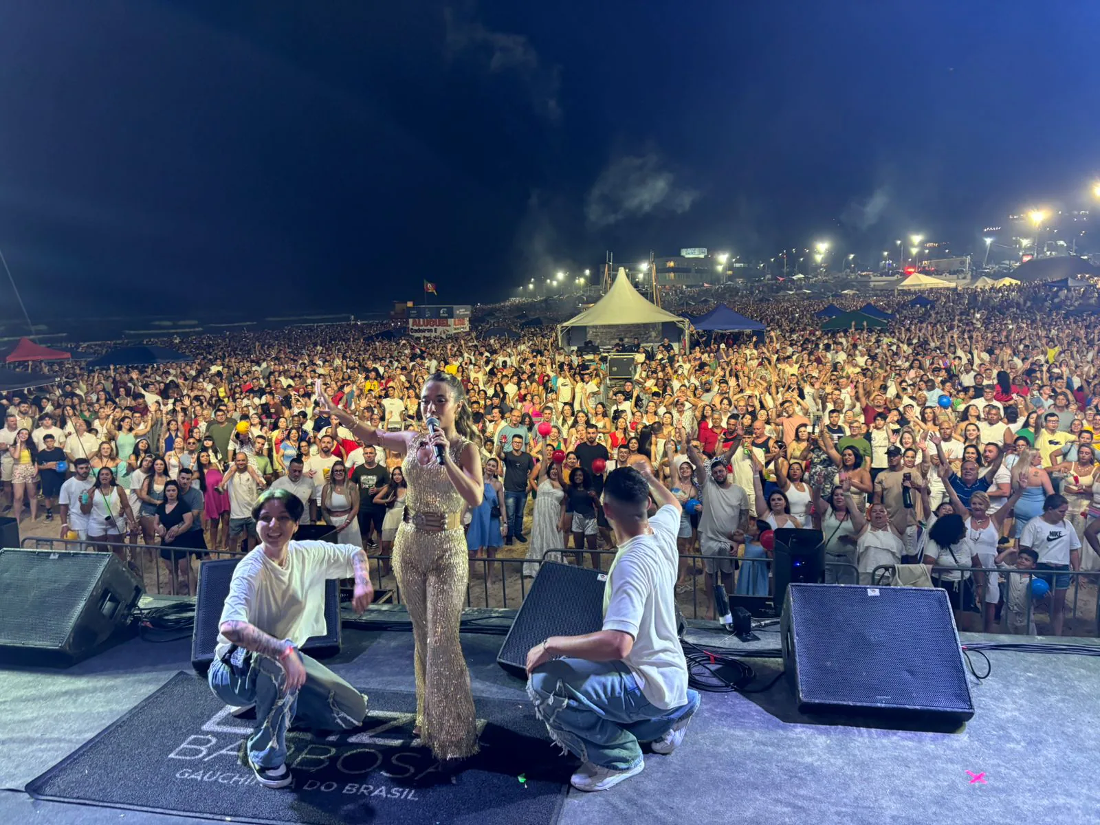 Artistas no palco e público na praia durante uma edição anterior do Réveillon de Torres