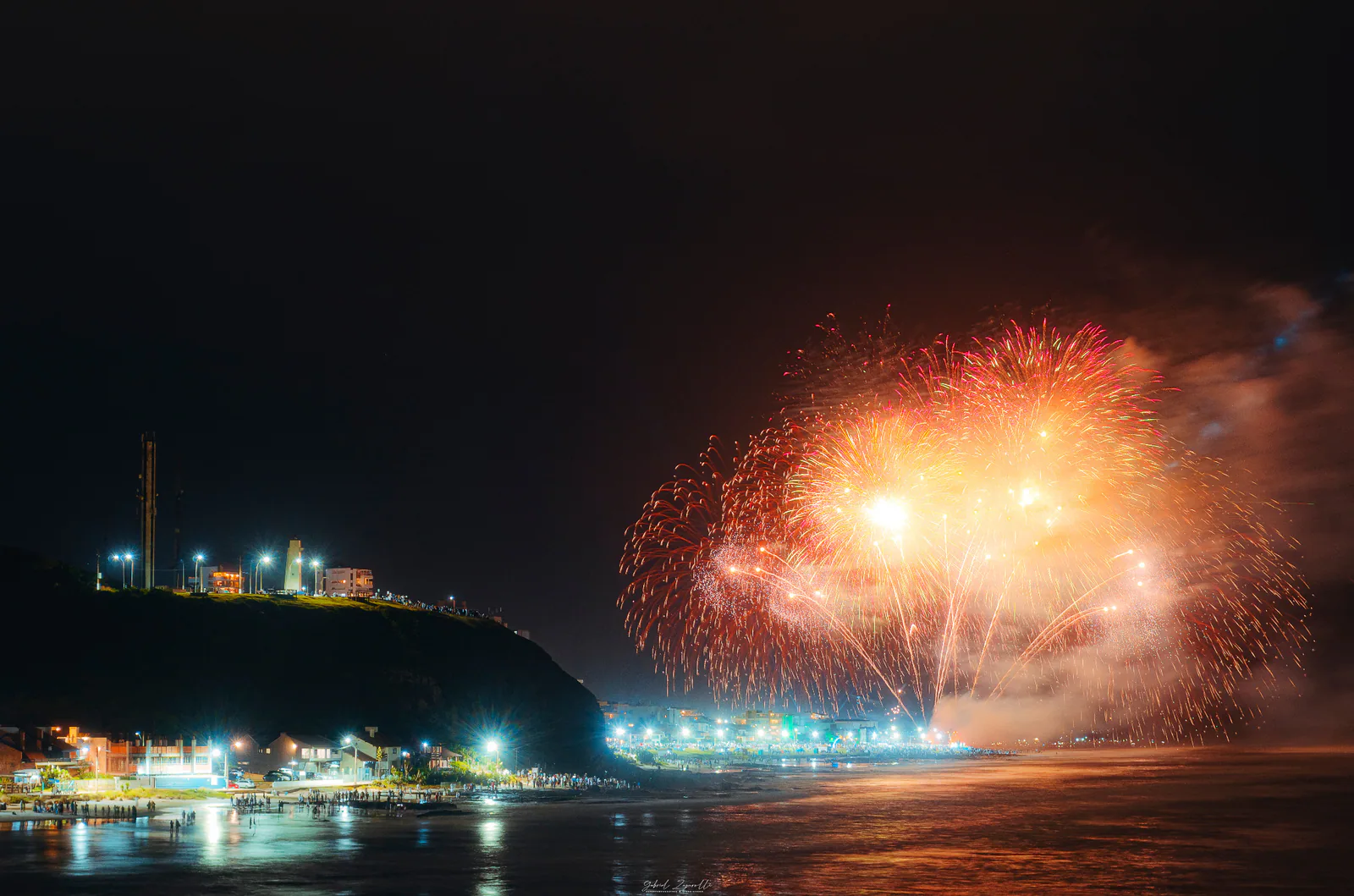 Fireworks over the sea beside Morro do Farol during New Year’s Eve in Torres