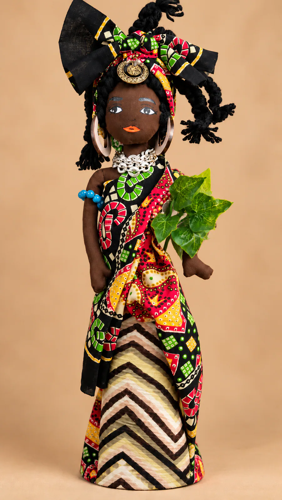 Muñeca artesanal de tela con vestido estampado, turbante y accesorios