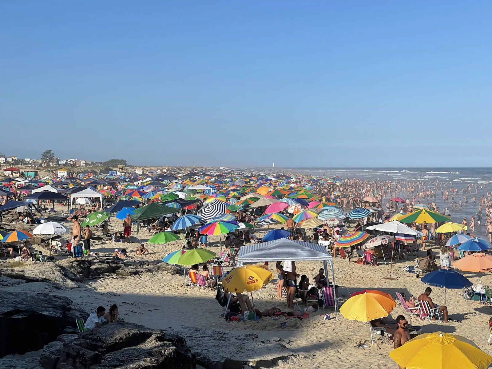 Praia Grande con numerosos bañistas y sombrillas de colores a lo largo de la arena