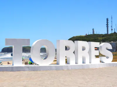 O letreiro TORRES, junto ao gramado da Prainha, é um ponto para fotografar a cidade com o mar e o Morro do Farol ao fundo.