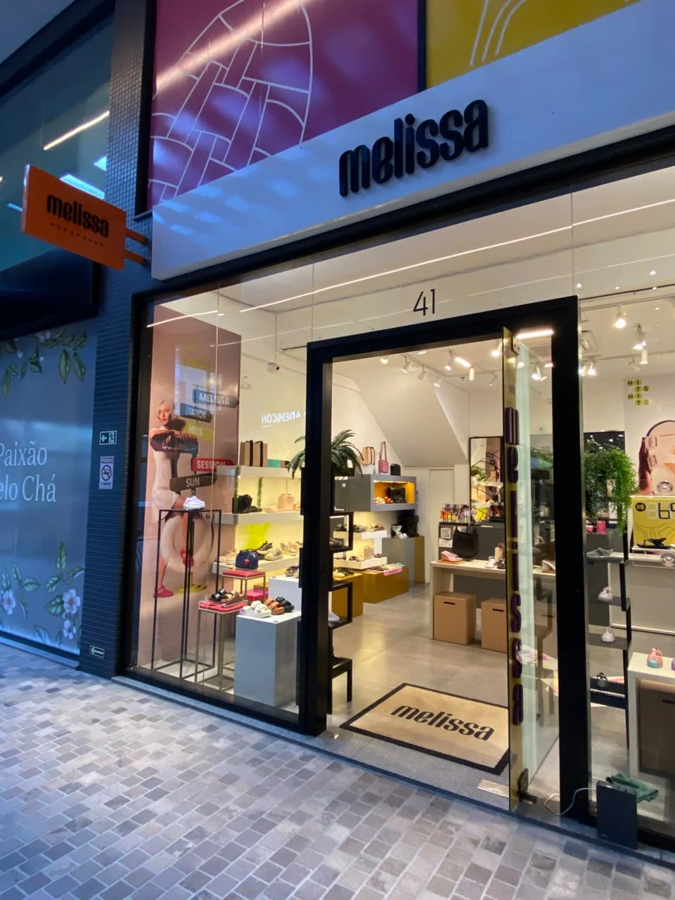 Entrada da loja Melissa com vitrines e expositores de calçados