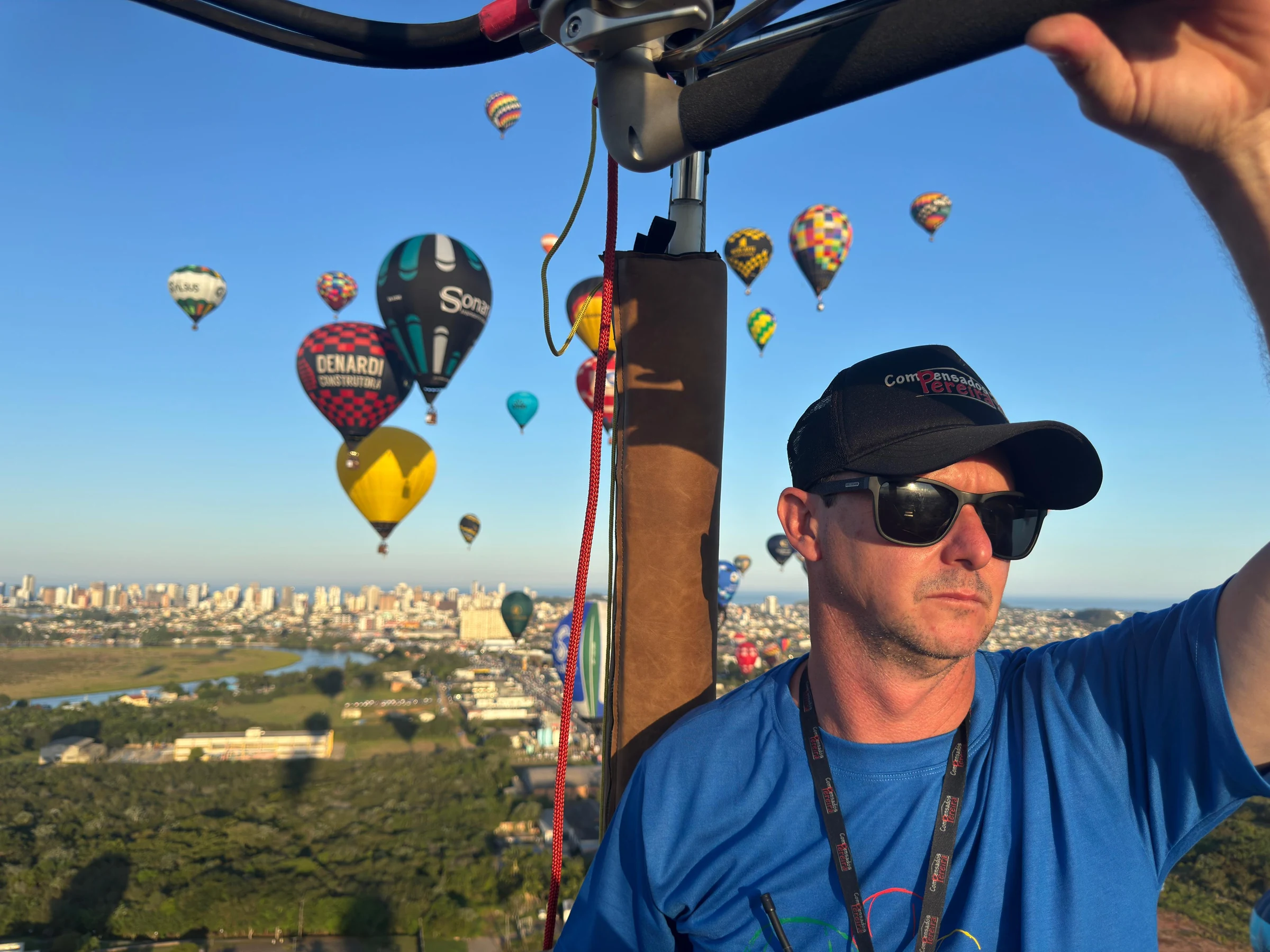 Piloto en la cesta de un globo con otros globos al fondo